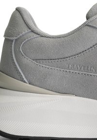 Baskets en daim gris avec une tige texturée, une semelle intermédiaire lisse gris clair et une semelle extérieure blanche antidérapante. Présente des coutures discrètes et un col rembourré.