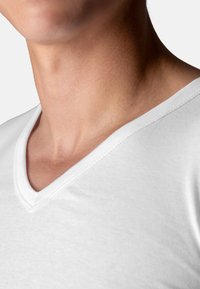 White cotton t-shirt with a V-neck design, featuring a smooth texture and clean finish along the neckline and hem.