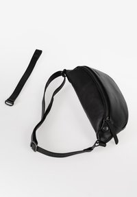 Zwarte leren heuptas met een gestroomlijnd ontwerp, ritssluiting, verstelbare riem en een soepele textuur. Voorzien van een subtiele logo-accent.