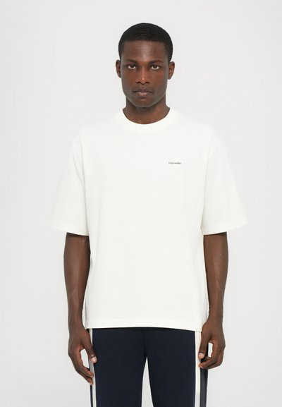 Weißes Baumwoll-T-Shirt mit kurzen Ärmeln, lockerer Passform und einem kleinen grauen Logo auf der linken Brust. Glatte Textur, runder Halsausschnitt.