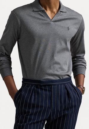 Šedé dlouhé rukávy polokošile s límečkem, doplněná námořnickými pruhovanými kalhotami s bočními kapsami a pasovým pásem. Jemný akcent loga na košili.