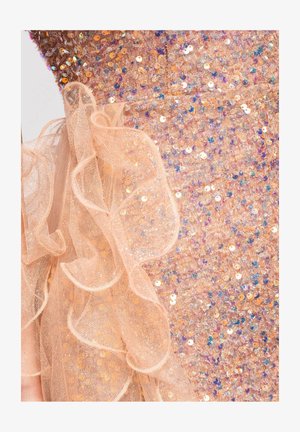 Tissu couleur pêche avec sequins irisés et volants transparents superposés créant une surface texturée et étincelante.