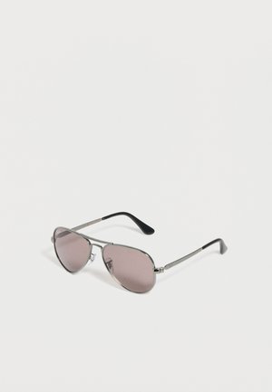 Pilot-solbriller med sølvramme, rosa-tonede linser og sorte stænger, der ligger på en hvid overflade.