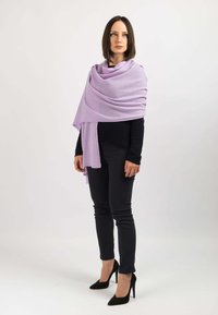 Lavendel sjal draperet over en sort sweater, parret med sorte skinny bukser og sorte højhælede sko. Blød tekstur, let stof, minimalistisk design.