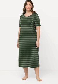 Camicia da notte a righe verdi con maniche corte, scollatura rotonda, fessure laterali e una consistenza morbida. Presenta righe scure e chiare alternate.