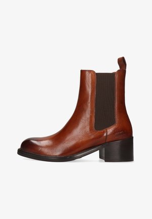 Brązowy skórzany botek za kostkę z zaokrąglonym noskiem, elastycznymi panelami bocznymi, pętelką do ściągania i piętą na słupku. Gładka tekstura z minimalną ilością detali.