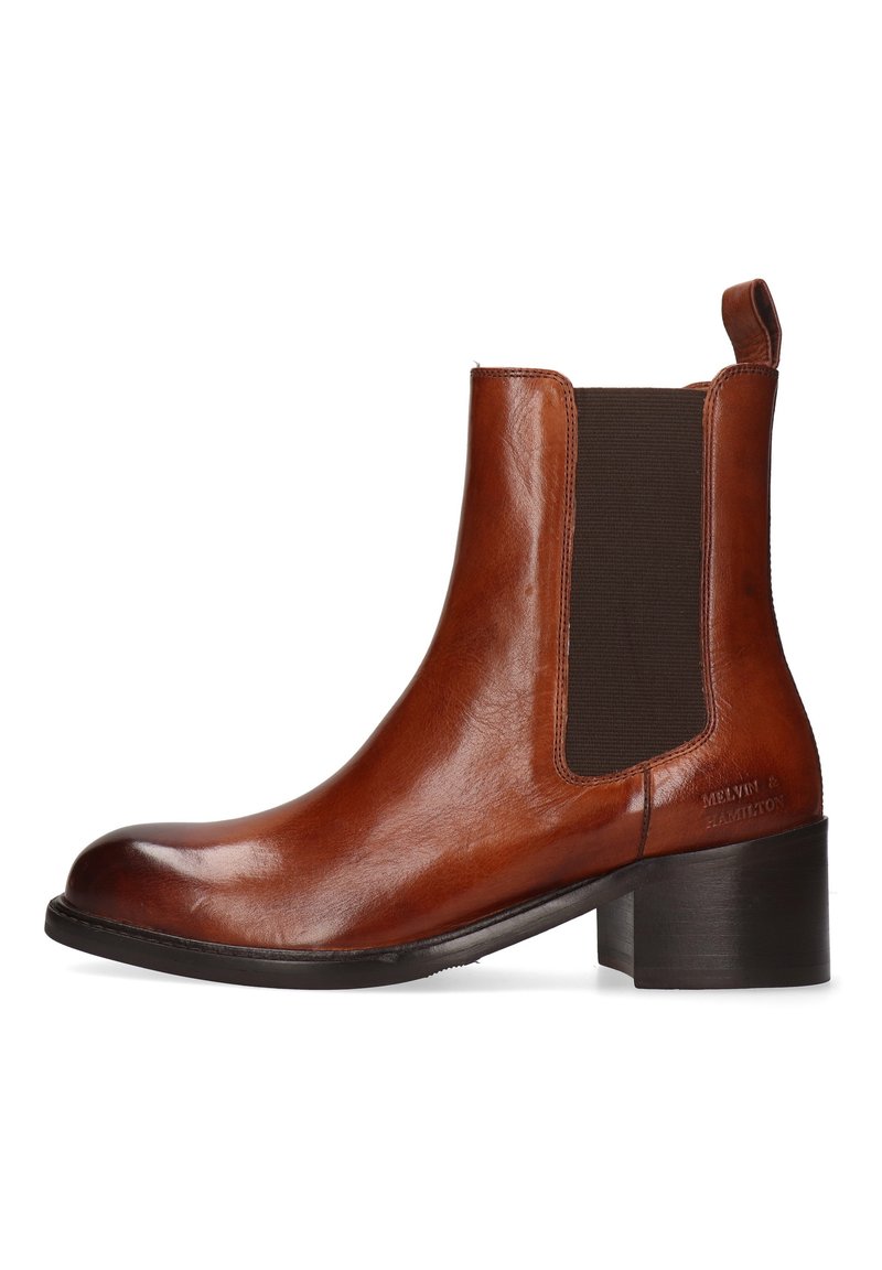 Bota de piel marrón para el tobillo con punta redondeada, paneles laterales elásticos, lengüeta y tacón apilado. Textura lisa con detalles mínimos.