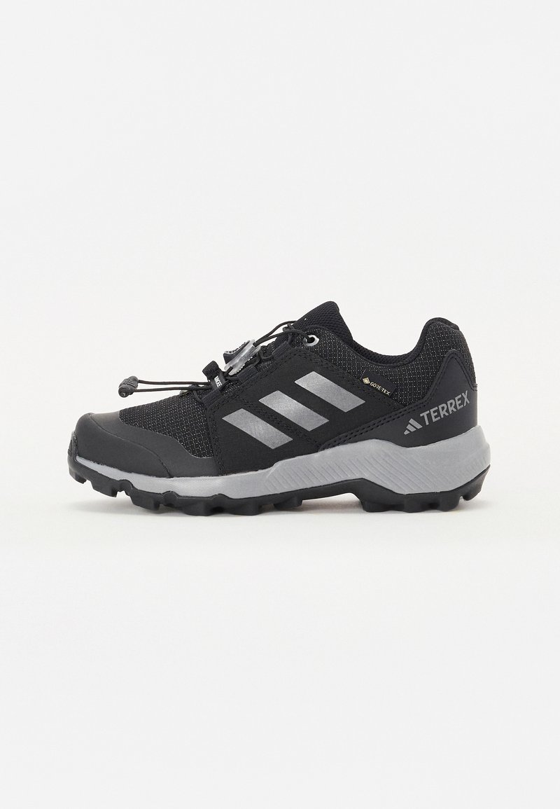 Black athletic shoes with a mesh upper, gray accents, a secure lace-lock system, and a rugged outsole for traction on various terrains.