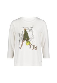 Frau mit Sonnenbrille, die einen kleinen Hund an der Leine führt, eine gelbe Handtasche trägt, mit Pariser Sehenswürdigkeiten und dem Text "Morgenspaziergang mit Beau" auf weißem T-Shirt.
