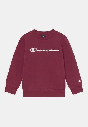 Bordowa bluza z długim rękawem z białym logo „Champion” na piersi oraz małym logo na mankiecie lewego rękawa.