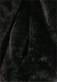 Svart konstpäls med en mjuk, tät textur, som har en slät, något glansig yta och ett plyschigt, högfibrigt utseende.