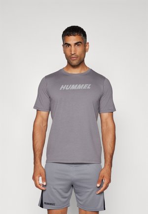 T-shirt de sport gris avec des manches courtes et un col rond, mettant en avant un grand logo "HUMMEL" sur la poitrine. Assorti à un short gris.