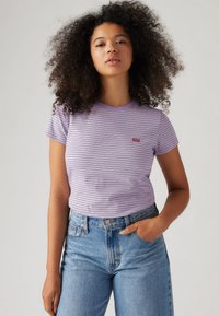 Purple and white striped t-shirt with a round neck and short sleeves, featuring a small red Levi's logo on the chest and a fitted design.