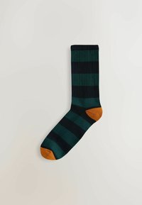 Multikleurige sok met donkergroene en zwarte stripes, voorzien van een oranje teen en hak. Gemaakt van zachte stof met een geribbelde textuur.