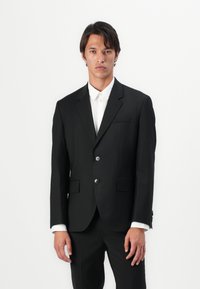 Black tailored suit jacket, made of smooth fabric, featuring two buttons, notch lapels, and a single chest pocket. White shirt visible underneath.