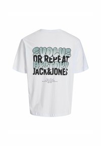 Balta medvilninė marškinėliai trumpomis rankovėmis su ryškiais juodais ir mėlynais užrašais ant nugaros: "EIKITE Į PRIEKĮ ARBA KARTOKITE ISTORIJĄ JACK&JONES."