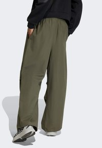 Prostrane, maslinasto zelene cargo hlače s elastičnim pojasom, koje imaju bočne džepove, laganu tkaninu i širok kroj za udobnost.