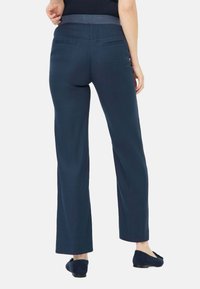 Dunkelblaue Hose mit geradem Bein, featuring eine angenehme Textur und elastischem Bund, von hinten gezeigt mit zwei Gesäßtaschen.