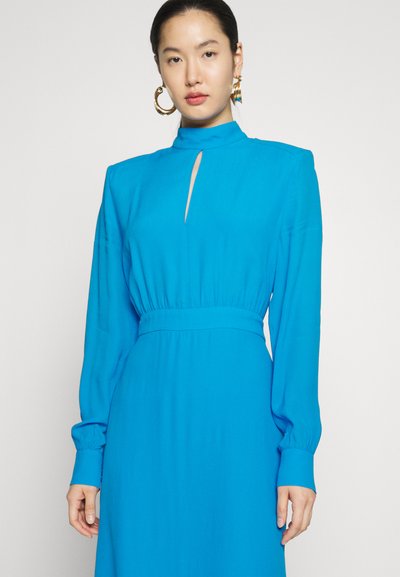 Długa, jasnoniebieska sukienka z długim rękawem, wysokim kołnierzem, dekoltem w kształcie łezki i dopasowaną talią, wykonana z gładkiego materiału z marszczonymi rękawami.