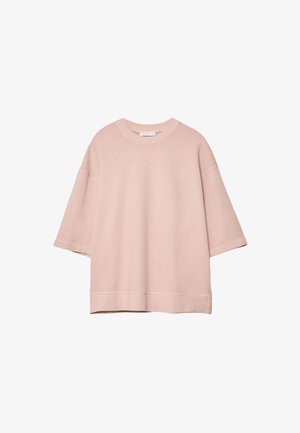 Přesně padnoucí svetřík s krátkými rukávy v nadměrné velikosti, světle růžové barvy, s kulatým výstřihem a spadlými švy na ramenou, na bílém pozadí.