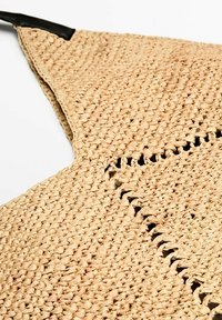 Torebka z plecionego słomy o teksturowanej powierzchni, w kształcie trójkąta, z czarnymi skórzanymi detalami na górze.