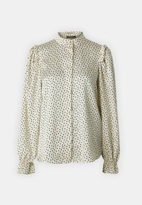 Krémová blúzka s vysokým golierom, predným zapínaním na gombíky a dlhými puff rukávmi s volánikmi. Čierny nepravidelný bodkovaný vzor po celom povrchu. Hladká saténová textúra.