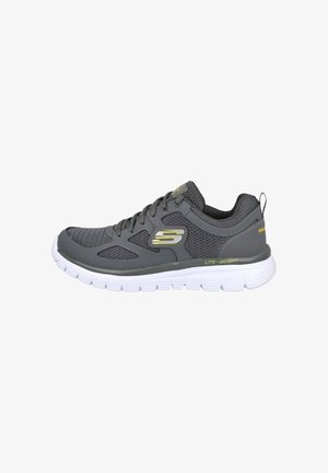 Zapatilla deportiva gris con parte superior de malla texturizada, suela de goma blanca, acentos circulares y logotipo de "S". Diseño ligero para mayor comodidad.