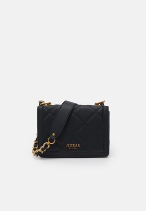 Black quilted leather Guess crossbody bag with gold chain strap and logo plaque reading "GUESS EST 1981" on front.