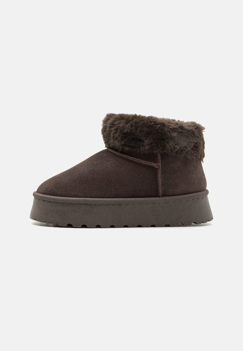 Bottines en daim marron avec col en fausse fourrure, bout rond et semelle en caoutchouc texturé. Présentent une couture simple et un design profil bas.