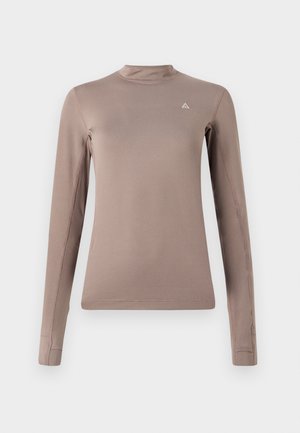 Haut à manches longues en tissu marron clair, doté d'un col montant, d'une forme ajustée, de coutures minimales et d'un petit logo sur la poitrine.