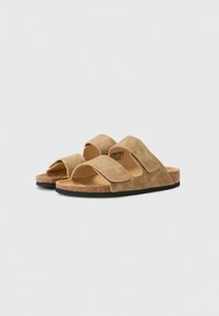 Brune ruskinds slide-sandaler med to justerbare stropper, korkfoderd og gummisål, der har et minimalistisk design og åben tå stil.