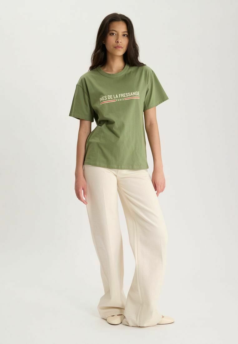 T-shirt en coton vert olive à manches courtes et col rond, avec un texte logo blanc et rouge imprimé à l'avant.