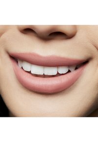 Nærbilde av en glatt, lys rosa leppe med en naturlig glans, som avdekker rette, hvite tenner i et avslappet smil; myk hudtekstur.