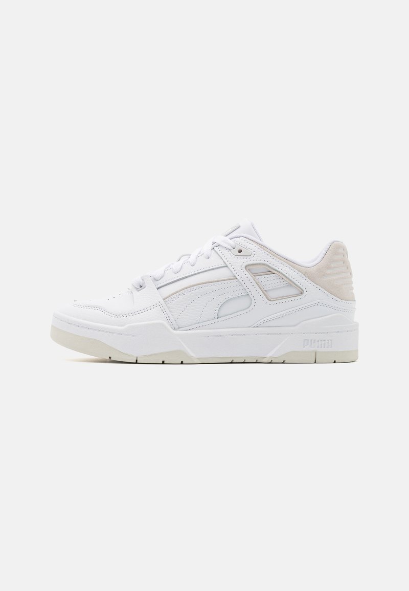Shoe atlético branco feito de couro texturizado. Apresenta uma sola de borracha lisa, detalhes em costura, ventilação lateral e um acento cinza claro.