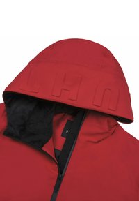 Veste à capuche rouge avec une douce doublure en polaire noire, lettres en relief bien visibles sur la capuche et fermeture éclair à l'avant.