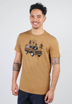 T-shirt en coton marron avec un motif de camionnette vintage, des planches de surf, des arbres et un design de soleil. Manches courtes, col rond.
