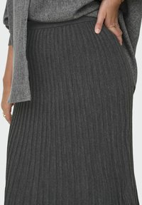 Gonna a coste grigio scuro con vita aderente. Il tessuto ha una texture morbida e righe verticali per un tocco in più.