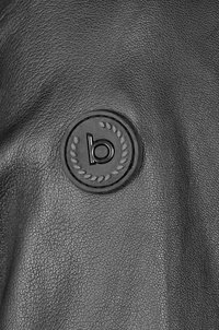 Čierny kožený povrch s okrúhlym čiernym logom s písmenom "b" a dizajnom vavrínového listu vyrazeným v strede.