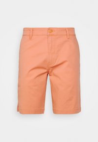 Shorts pour hommes de couleur corail, longueur genou, avec passants pour ceinture, fermeture à bouton et zip sur un fond blanc uni.