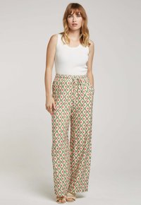 Pantalons à jambes larges à motif en vert, rouge et crème. Taille élastique avec cordon de serrage. Tissu lisse et design géométrique. Mélange de coton.