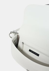 Borsa a tracolla bianca in pelle caratterizzata da un design strutturato, hardware in argento, una tasca interna con zip e un'etichetta del marchio. Texture liscia con uno stile minimalista.