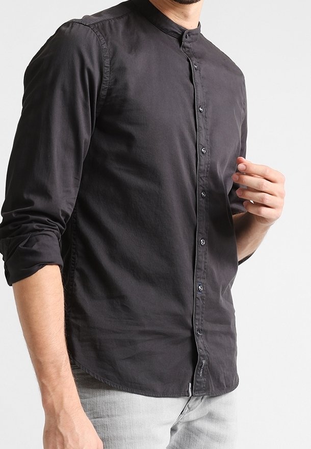 Camicia nera a maniche lunghe con colletto a banda e apertura frontale. Tessuto liscio e leggero con una leggera lucentezza.