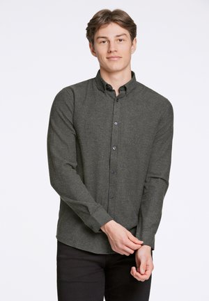 Camisa de manga larga de botón en un verde oscuro, hecha de un tejido texturizado. Presenta un cuello clásico y botones negros, con un diseño ajustado.