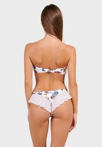 Bikini komplet s uzorkovanim bandeau gornjim dijelom s kopčanjem i naboranim donjim dijelom bijele boje; cvjetni uzorak u raznim bojama.