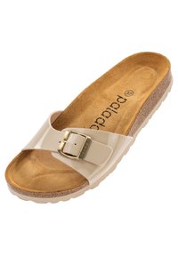 Beige slide sandal med en glansig ovandel, justerbart spänne och mjuk mocka fotbädd. Har en kork-mellansula och gummiyttersula.