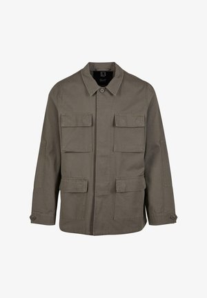 Khaaki színű vászon keverékből készült praktikus dzseki, egyenes szabással, két mellzsebből és gombos mandzsettával. Simább textúrával és letisztult dizájnnal rendelkezik.