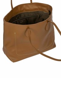 Sac fourre-tout en cuir marron avec une finition texturée, deux poignées et des coutures blanches. L'intérieur a une doublure sombre avec une poche zippée.