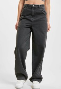 High-waisted, black denim jeans with wide legs, visible stitching, front pockets, and a silver button closure. Textured fabric.