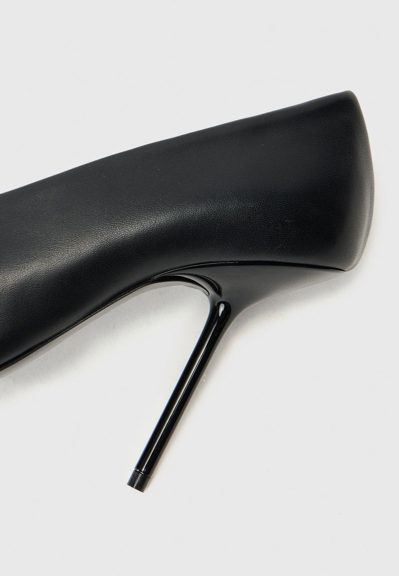 Schwarzer High Heel mit samtigem Lederoberteil, spitzem Zeh und glänzendem Stöckel, der ein sauberes, schlankes Design aufweist.