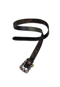 Cinturón de cuero negro con una hebilla metálica adornada con piedras preciosas de colores y un acabado texturizado a lo largo de la correa.